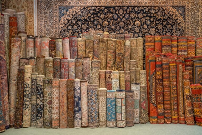 persian rugs stacked in a persian rug gallery store with brand new and antique styles based on value and history and investment