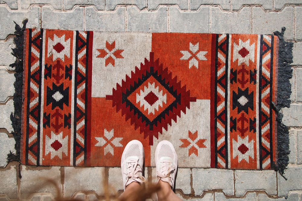 standing on a persian rug placed outside in an entry way for decor for the outdoors and to make home look bold and grand