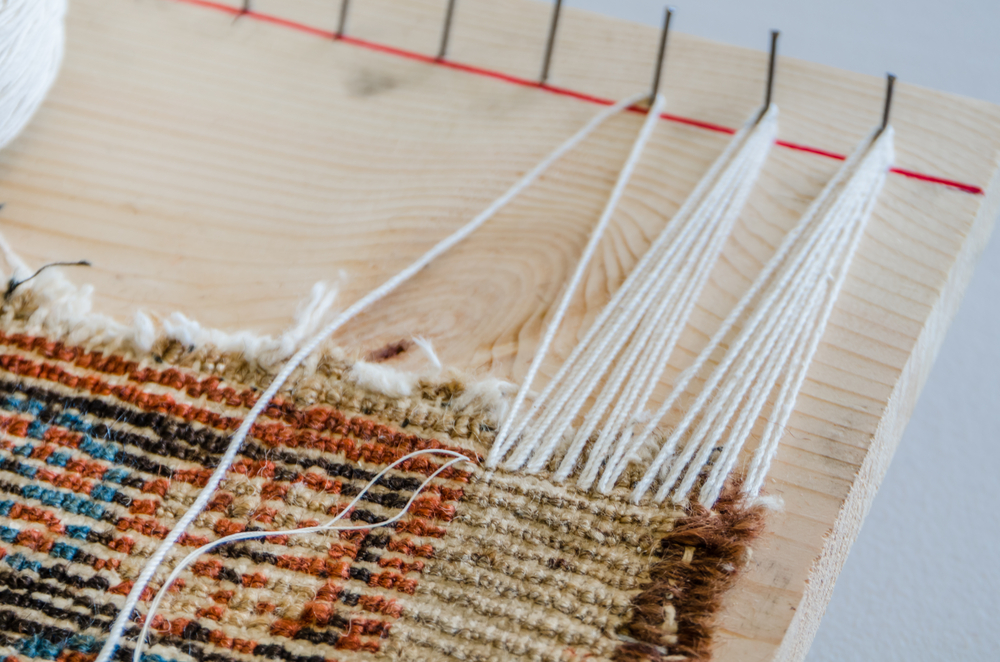 reweaving and fixing the fringe that is becoming frayed on a persian rug