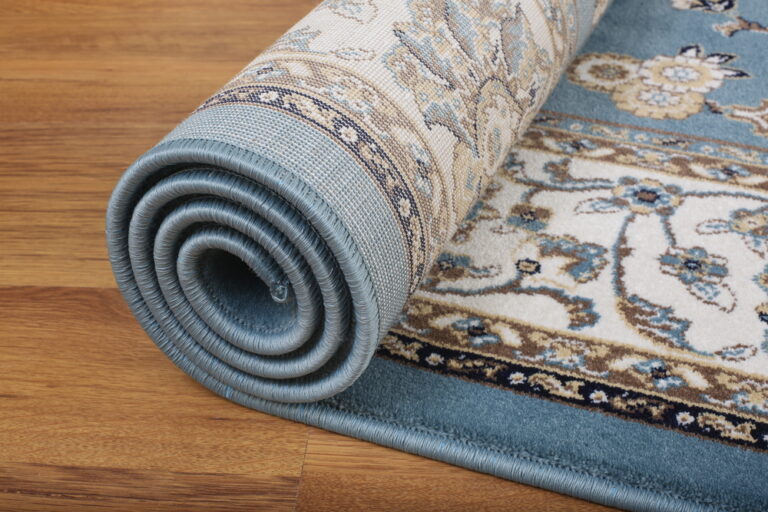 rolling out a persian rug onto a hardwood floor to decorate a home and improve the look